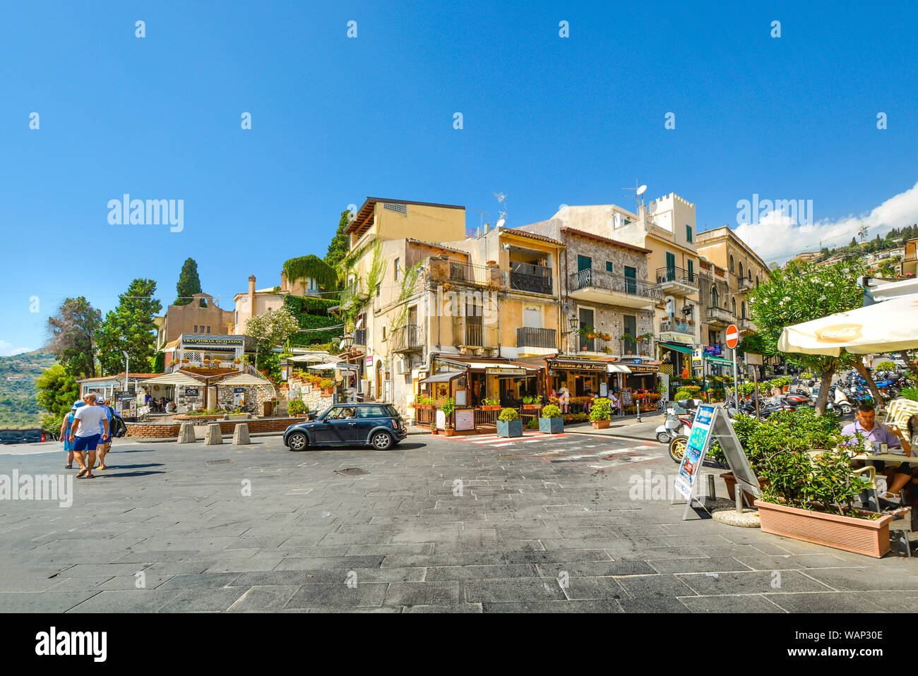 Busy corner with cafes and shops at the end of the main street, Corso Umberto, in the Sicilian city of Taormina Italy on a summer day Stock Photo