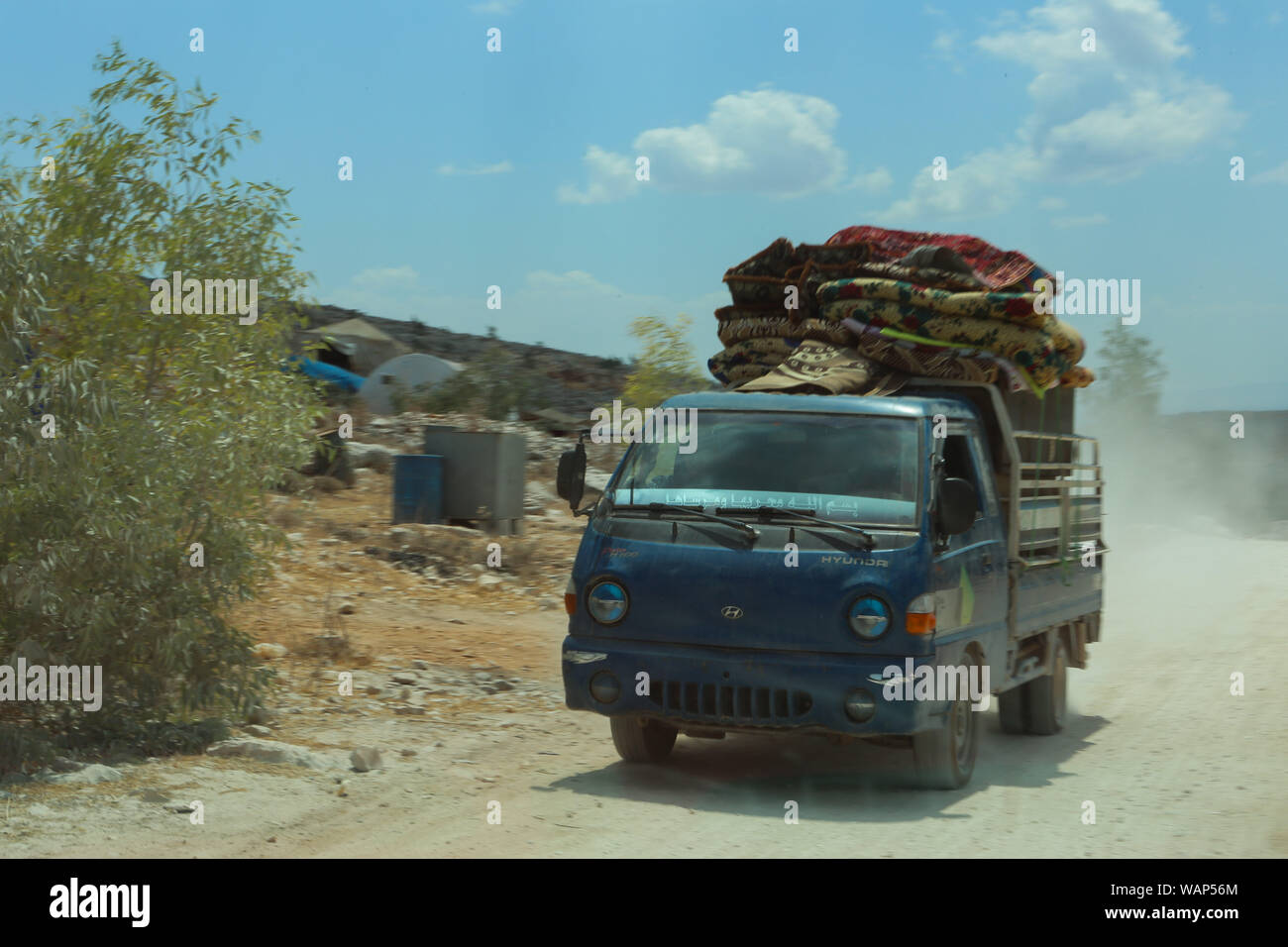 August 21, 2019: Cars and trucks carry the furniture of displaced Syrians heading to the Turkish border following the current government offensive. In recent weeks the Syrian government has stepped up a military campaign against rebel-held bastions in the Idlib and Hama provinces in north-western Syria following the cessation of a truce. The campaign has sparked further internal displacement, especially recently from the Khan Sheikhoun and the nearby villages of Morek, and Latamneh, as the government recently seized them from the opposition. It is estimated that hundreds of thousands of people Stock Photo