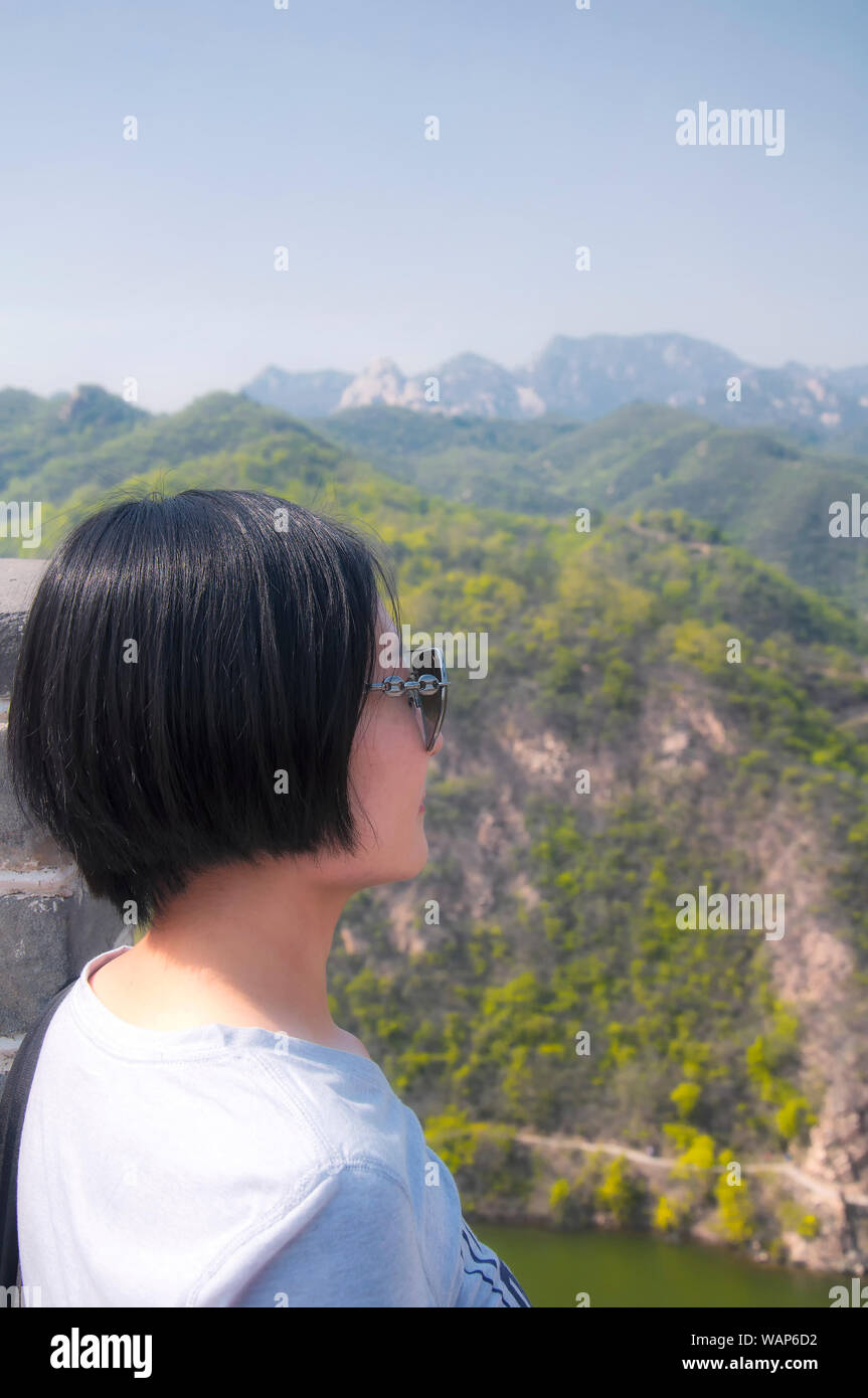 A Chinese Woman With Short Hair Looking Out At The Great Wall Of