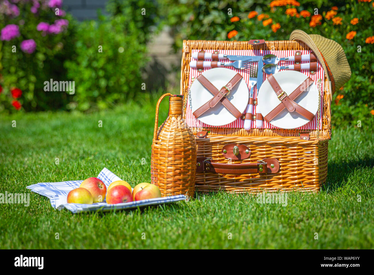 Picnic basket with food on green sunny lawn Stock Photo - Alamy