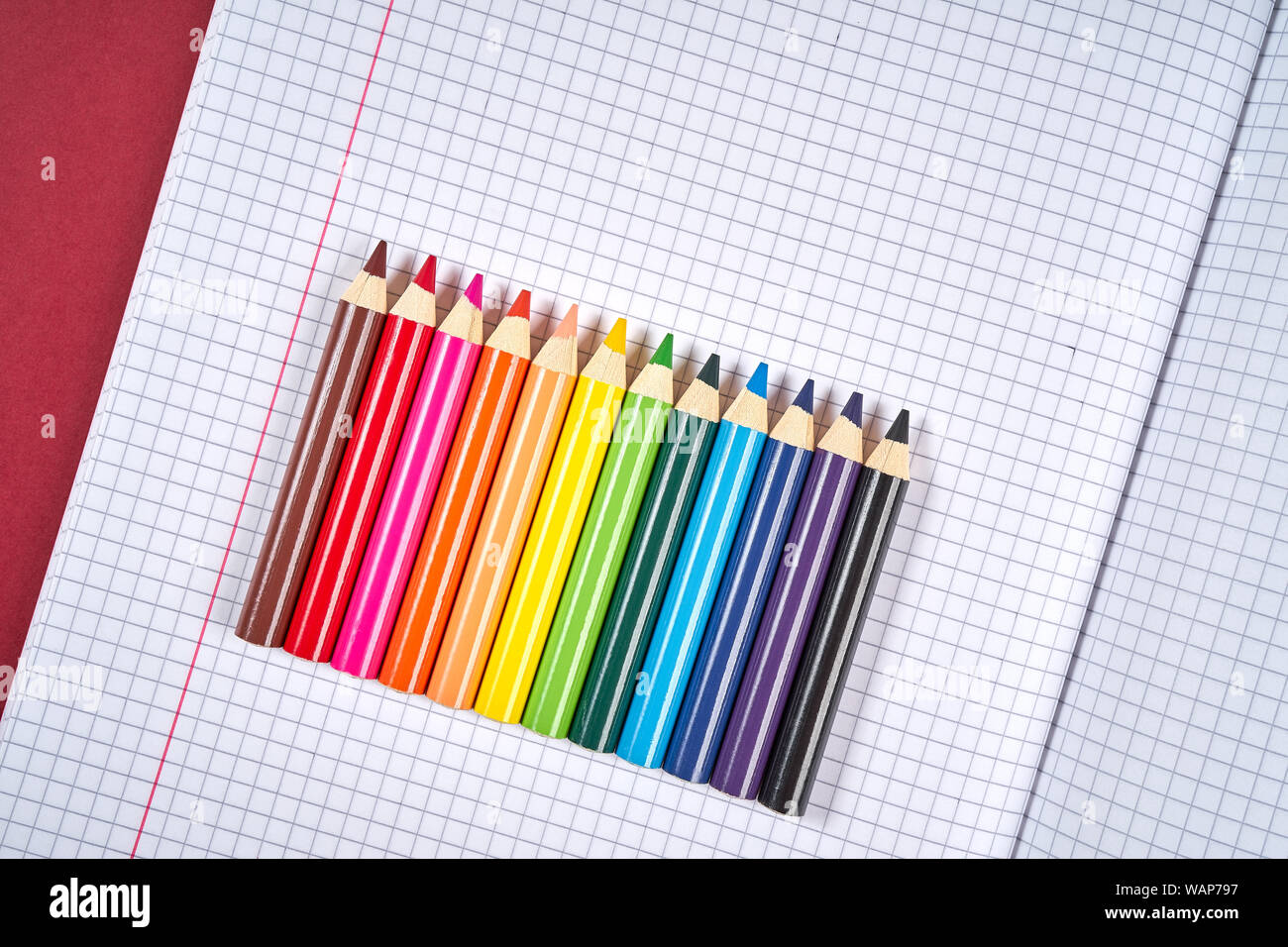 colored pencil crayons on an open checkered notebook Stock Photo