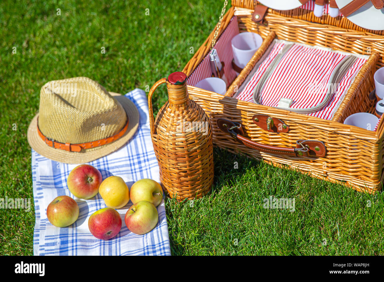 Picnic basket with food on green sunny lawn Stock Photo - Alamy
