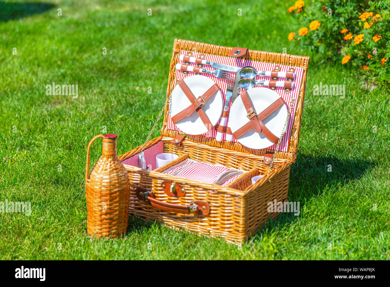 Picnic basket with food on green sunny lawn Stock Photo - Alamy