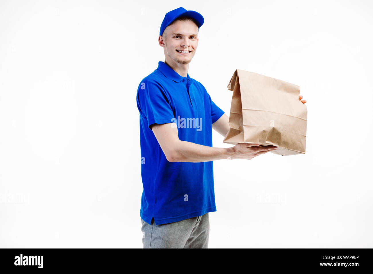 Delivery guy ships a big order to the adress written and smiles at the client friendly. Stock Photo