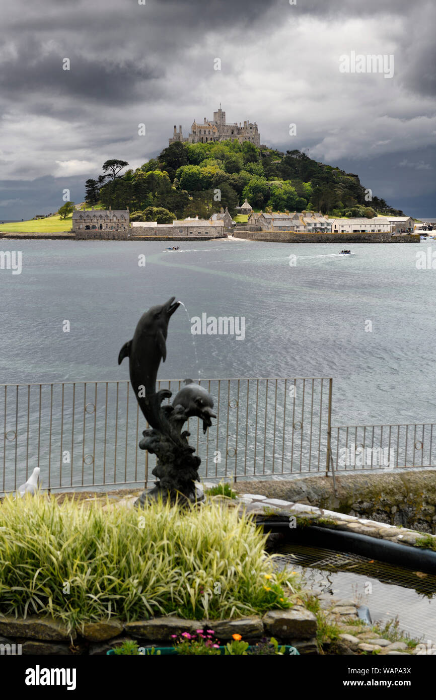 St Michael's Mount tidal Island with submerged walkway to Marazion from The Square with Two Dolphins fountain Cornwall England Stock Photo