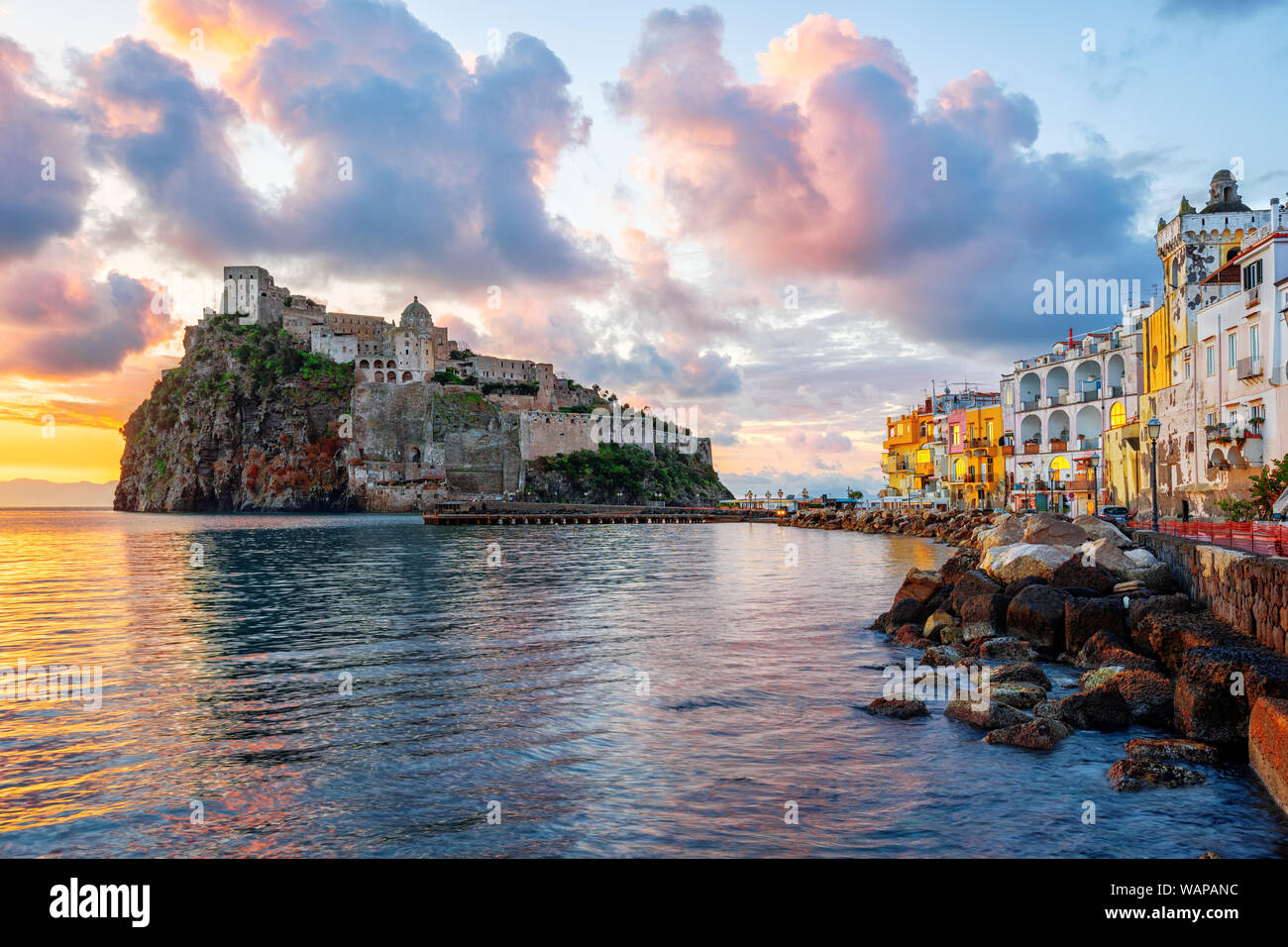 Historical Aragonese castle on a rock in Mediterranean sea, Ischia island, Gulf of Naples, Italy, in dramatic sunrise light Stock Photo