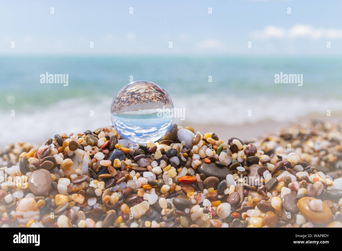 Glass round ball on the beach reflects the sea in summer Stock Photo ...