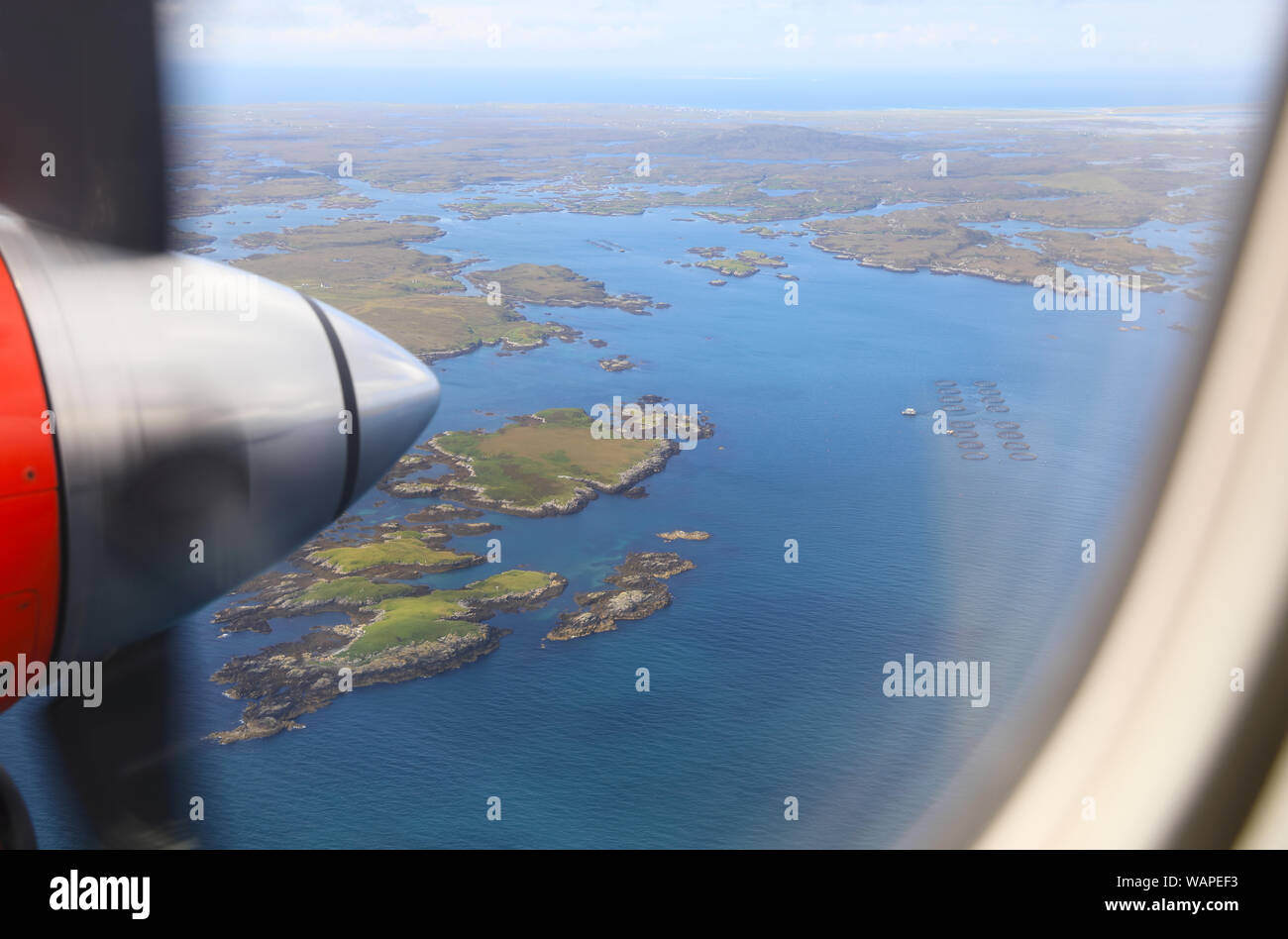 View from Loganair twin propeller plane flying over the Outer Hebrides towards landing in Benbecula, in Scotland, UK Stock Photo