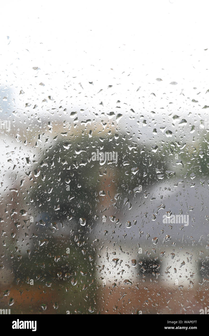 Rain drops trickling down a window in London, UK Stock Photo