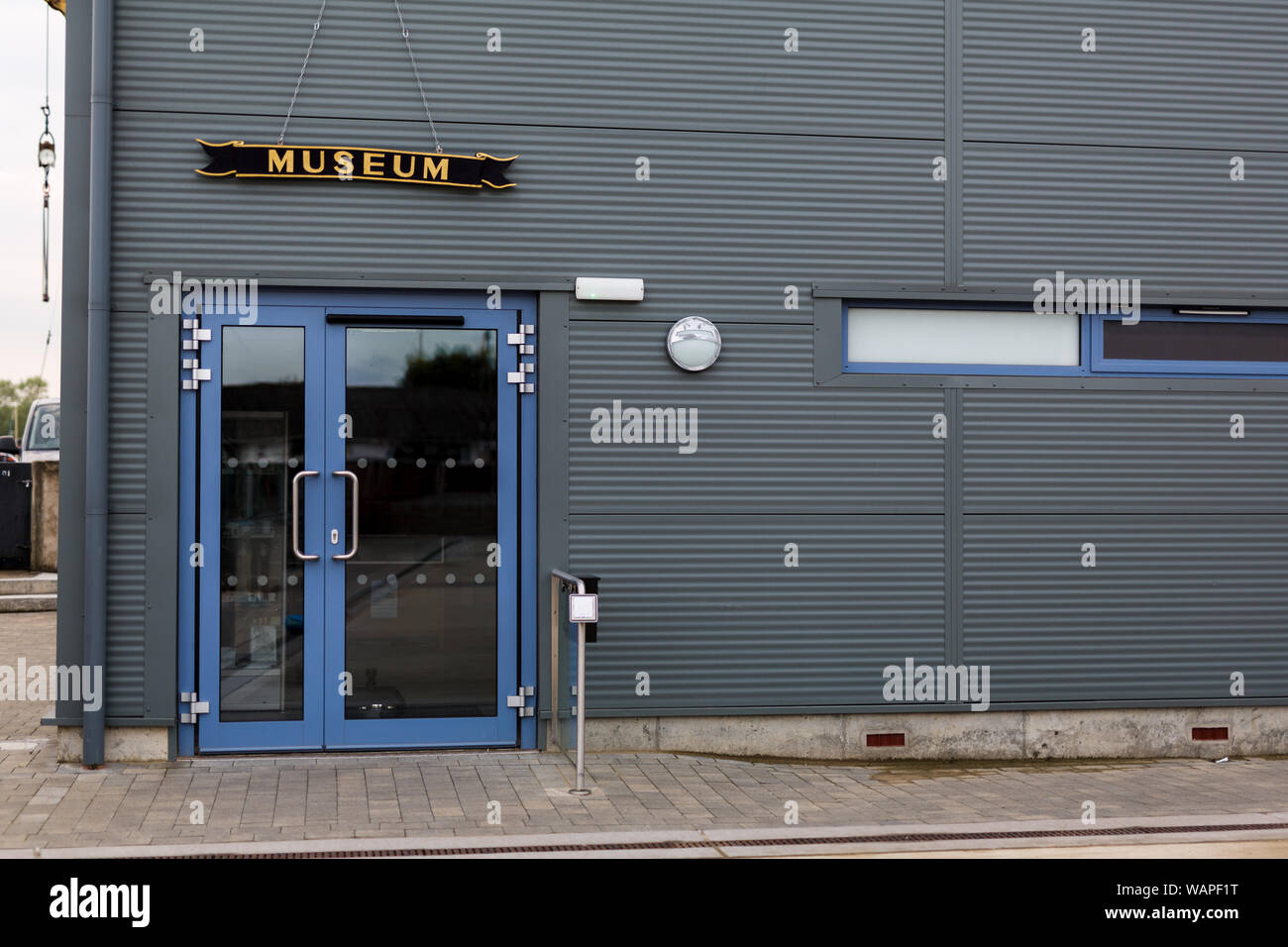 A modern looking museum building, there is a sign above the door. Outside walls are clean and tidy Stock Photo