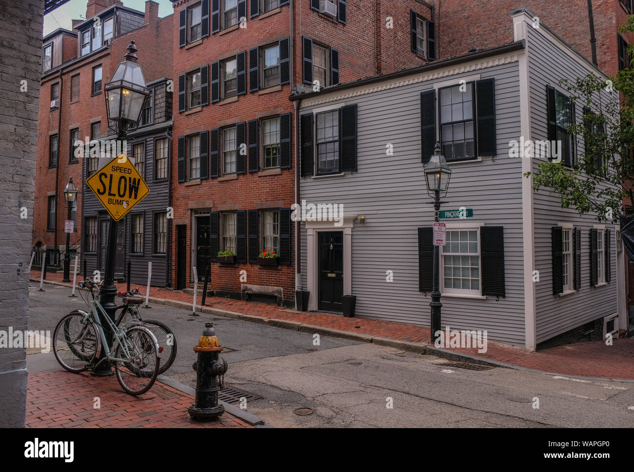 Acorn Street in Beacon Hill district, Boston, Massachusetts, USA - July 28, 2018: Two bicycles resting on a lamppost on a street in Beacon Hill, Bosto Stock Photo