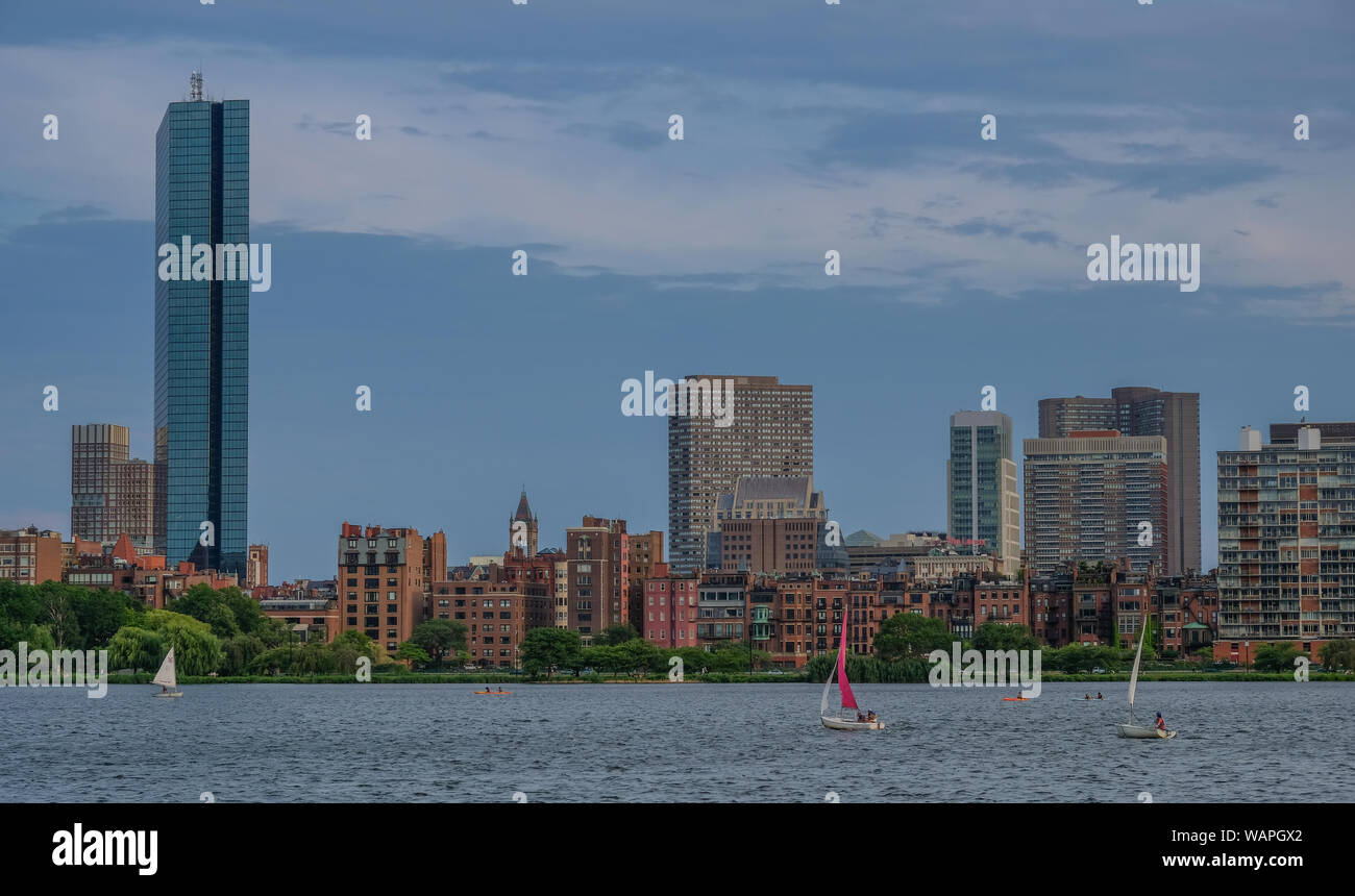 Charles river side in Boston, Massachusetts, USA - July 28, 2018: Sailboat traveling across Charles river with the skyline of the city in the backgrou Stock Photo