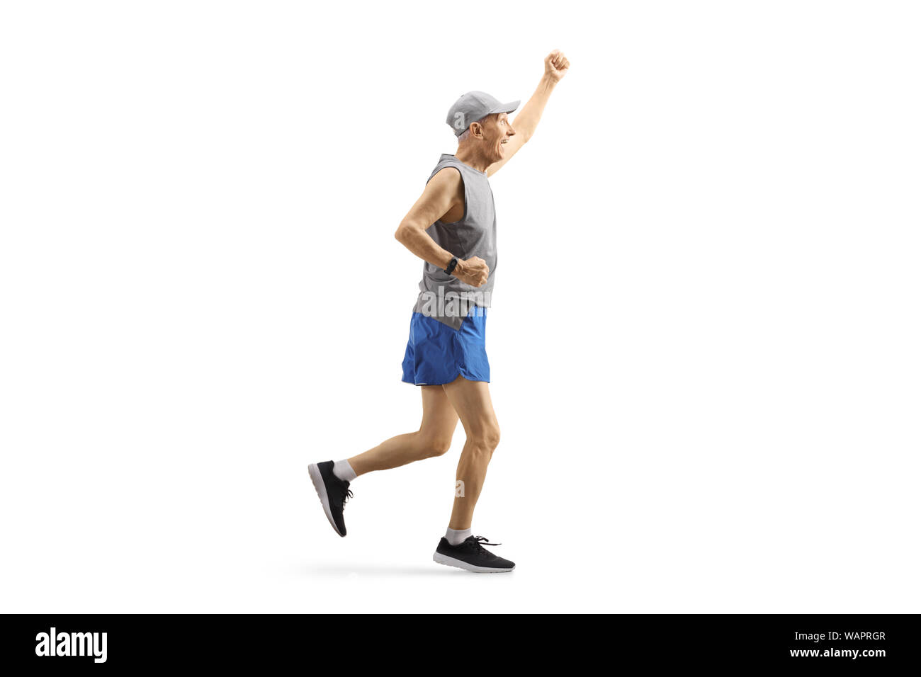 Full length profile shot of an elderly man in sportswear running and gesturing happiness isolated on white background Stock Photo