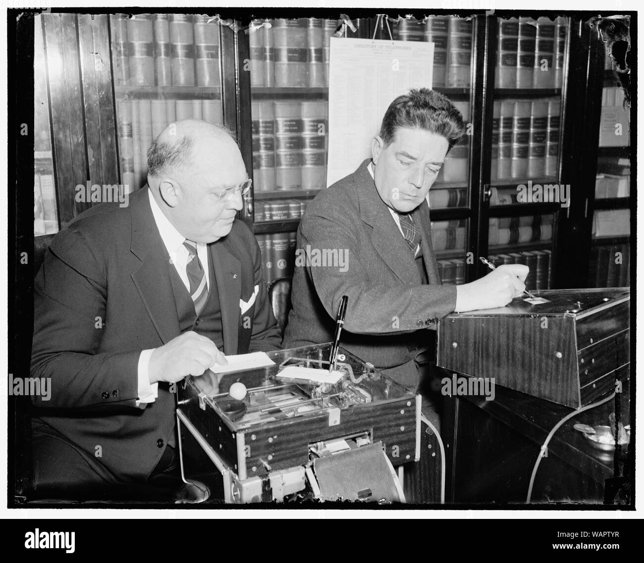 Demonstrates new signature machine to house member. Washington, D.C., March 18. The latest is the automatic electric signature machine invented by Glenn W. Watson, (left) who is shown in this picture demonstrating it to Rep. Lindsay C. Warren of North Carolina, 3/18/38 Stock Photo