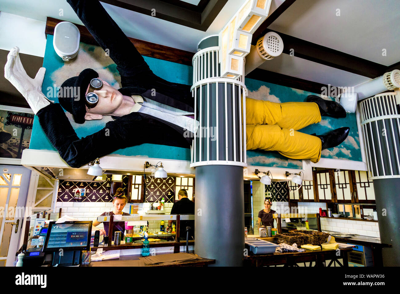 Giant mannequin with bowler hat and glasses above the kitchen of trendy pancake restaurant Manekin in Warsaw, Poland Stock Photo