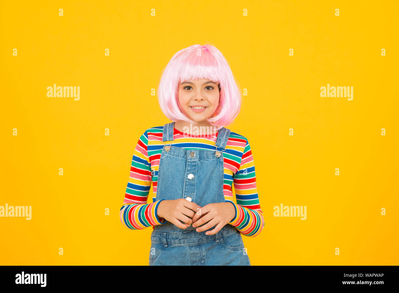 Otaku girl in wig smiling on yellow background. Cosplay character concept. Culture hobby and entertainment. Happy childhood. Anime fan. Cosplay kids party. Child cute cosplayer. Cosplay outfit. Stock Photo