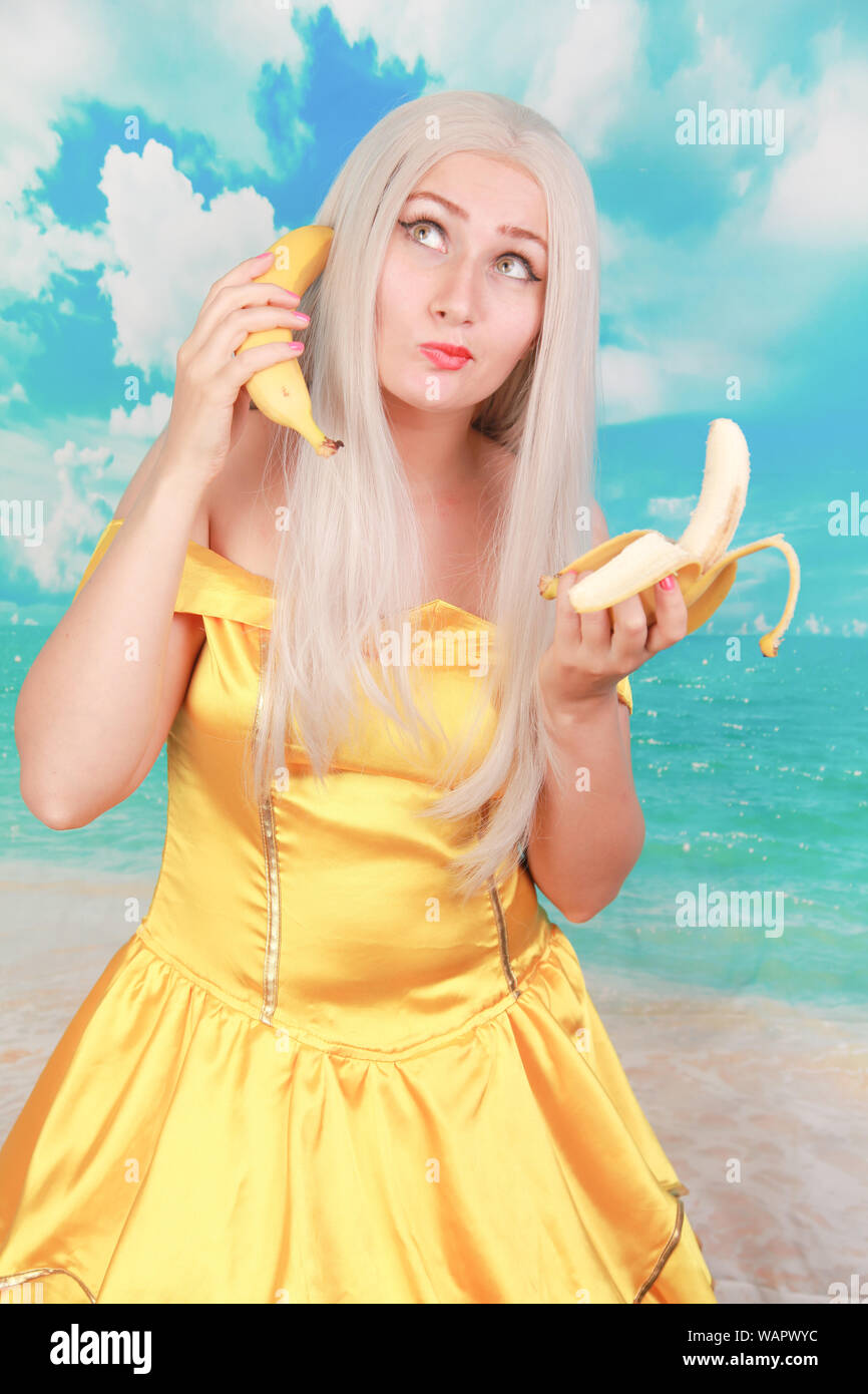 lady with pink lips holding banana like phone talk speak chat conversation Stock Photo
