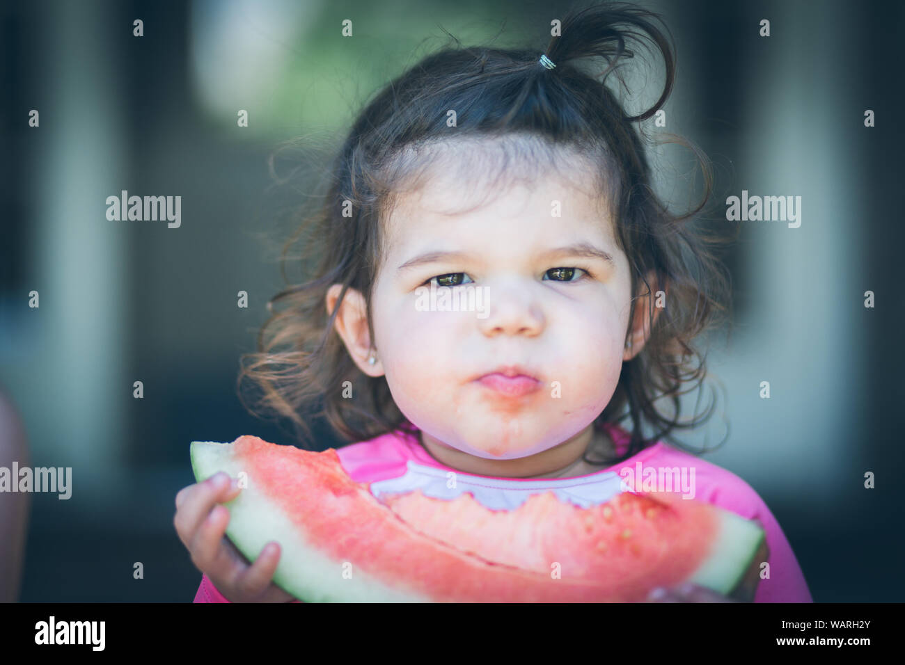 Little girl eating a watermelon in the summertime Stock Photo