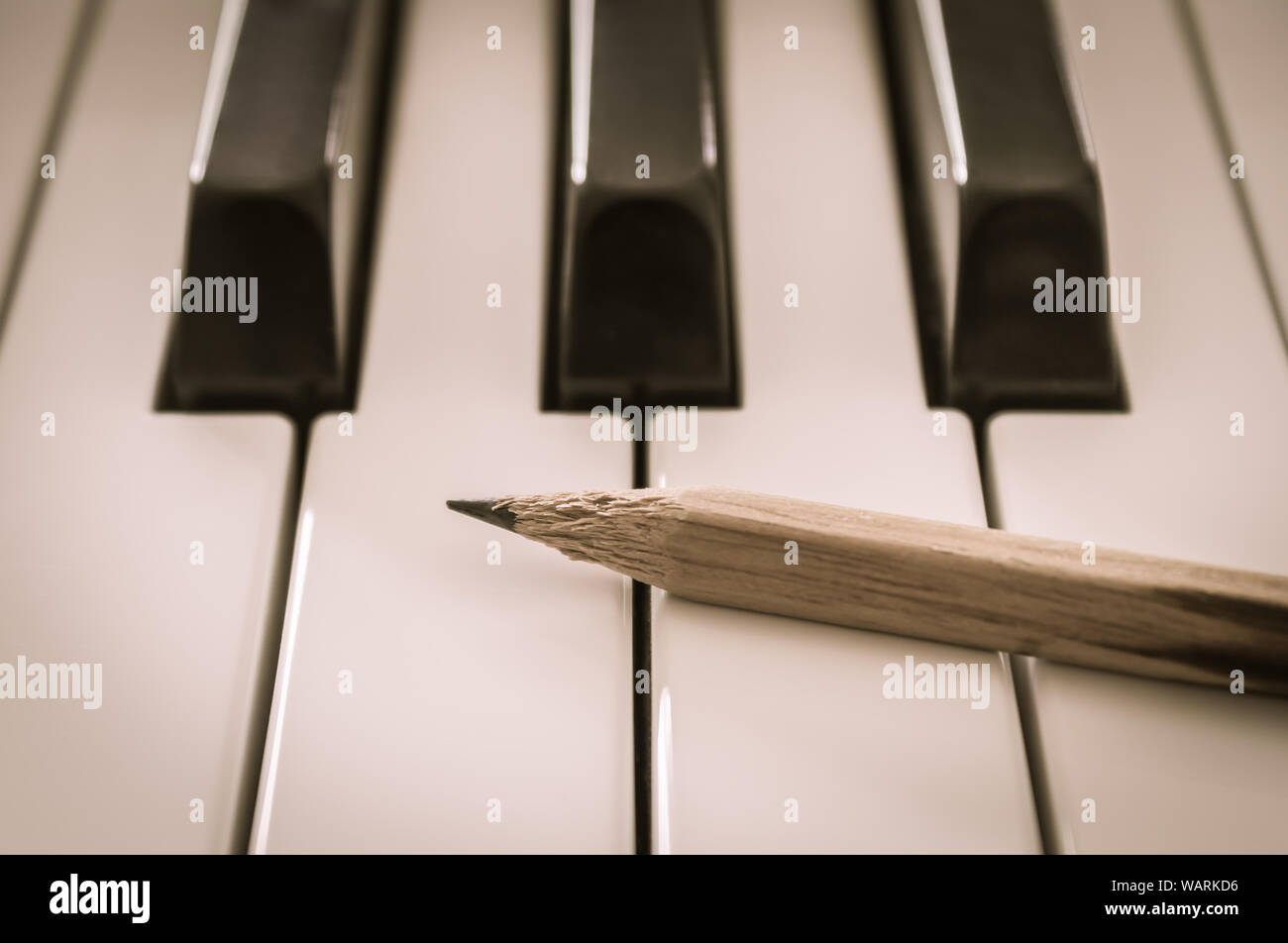 Old Pencil on White Keys of Electric Piano in Crosswise View. Concept