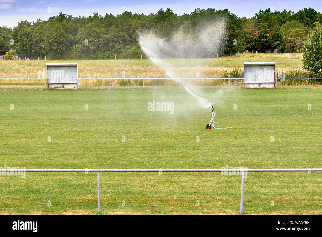 Sprinkler Watering Football Field. System Working On Fresh Green Grass