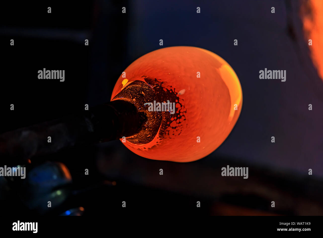 Glass blower manufacturing process, working on a bubble of melted glass