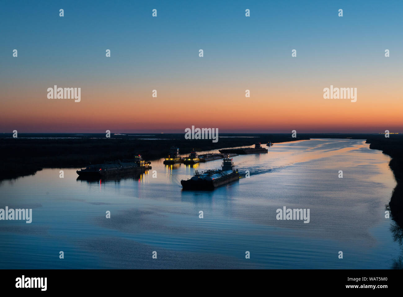 Dusk shot of barges traversing a short canal that connects the Sabine