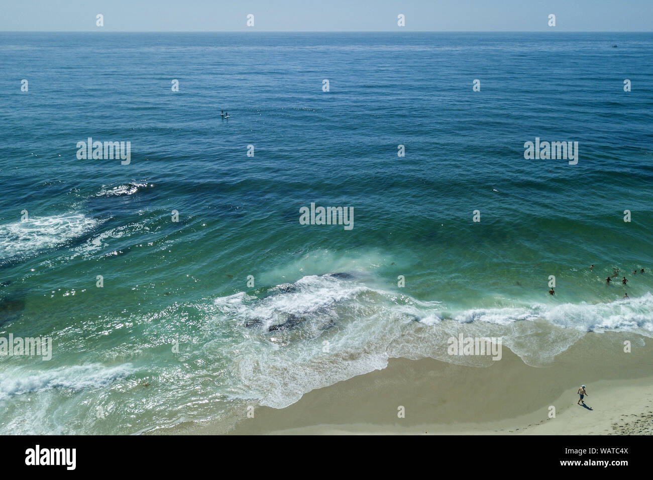 San Diego, California, USA. 21st Aug, 2019. Beach goers wade in the