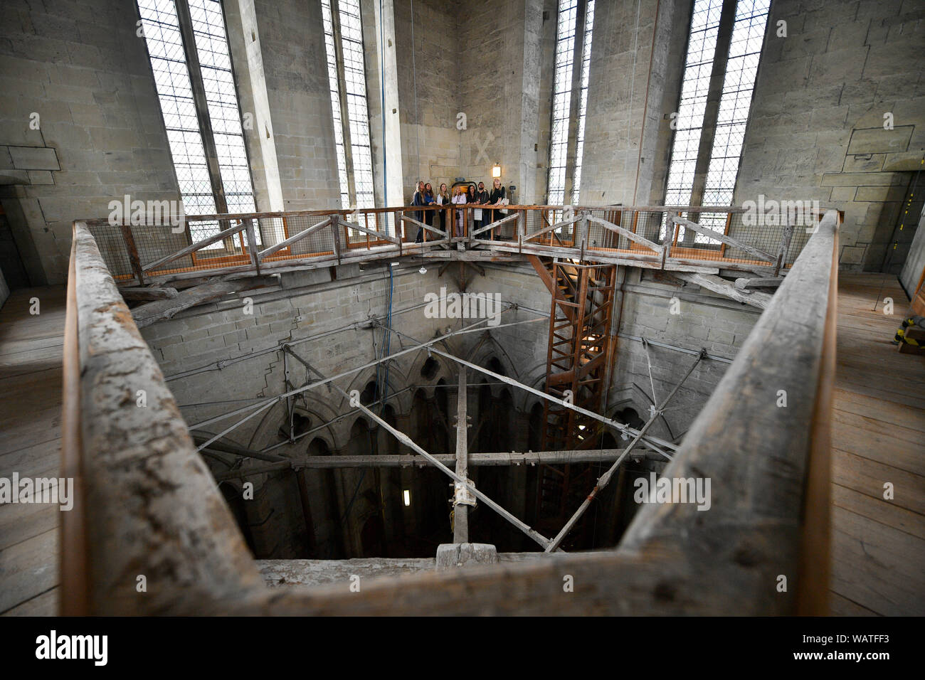 Visitors view the internal construction from the viewing gallery, inside the latter part of the Salisbury Cathedral tower construction phase, which dates from the 14th Century, during the cathedral's Tower Tour, where visitors are guided up to the base of the 123 metre tall spire, climbing 332 mainly spiral steps, through the vaulted roof space, past medieval stained glass and through the inner workings of the 13th century cathedral. Stock Photo