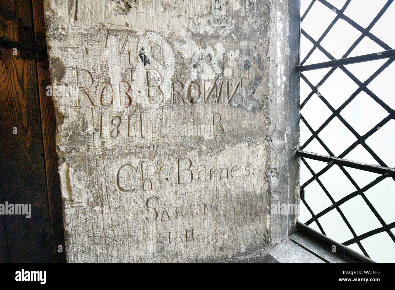 Graffiti scratched into an internal limestone wall, probably the work of two craftsmen, which can be seen during the Salisbury Cathedral Tower Tour, where visitors are guided up to the base of the 123 metre tall spire, climbing 332 mainly spiral steps, through the vaulted roof space, past medieval stained glass and through the inner workings of the 13th century cathedral. Stock Photo
