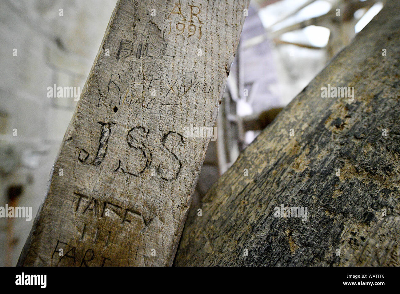 Graffiti on wooden beams, probably left by visitors at the spire base, which can be seen during the Salisbury Cathedral Tower Tour, where visitors are guided up to the base of the 123 metre tall spire, climbing 332 mainly spiral steps, through the vaulted roof space, past medieval stained glass and through the inner workings of the 13th century cathedral. Stock Photo