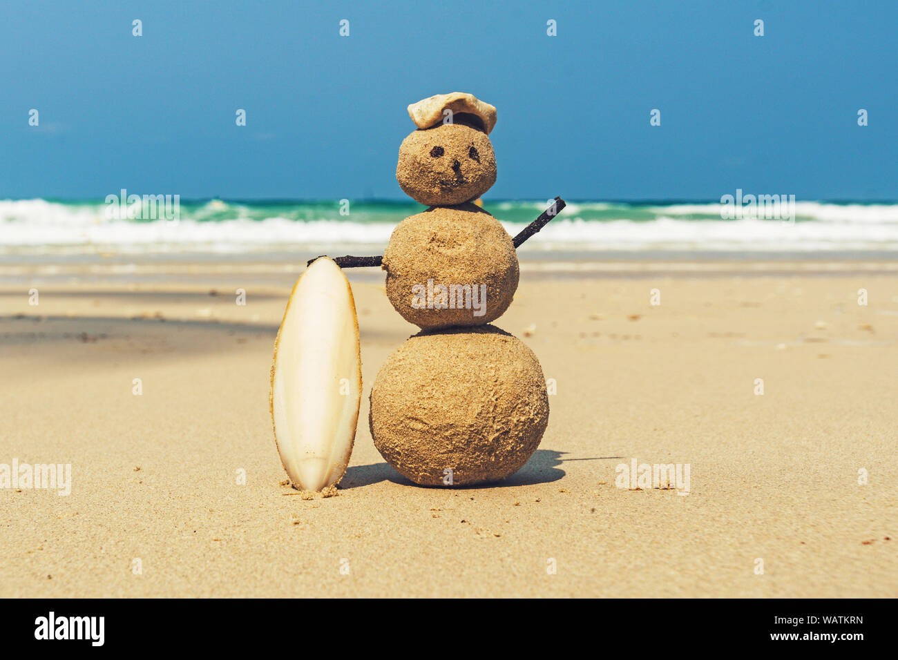 Sandman with blue sea background. snowman of sand stands on a clean sandy beach. yellow sand on the shore of the Andaman sea, tropical island. beautif Stock Photo
