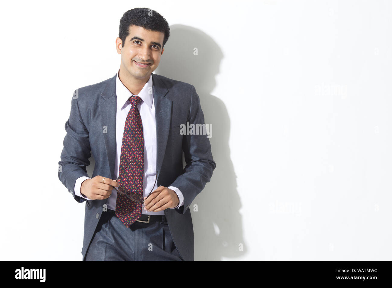 Indian business man standing against wall hi-res stock photography and ...
