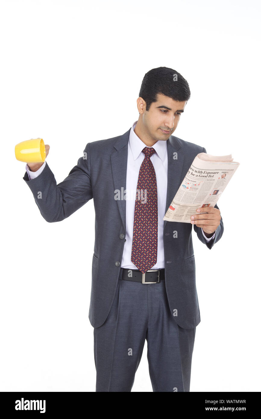 Businessman reading a newspaper and falling a cup of coffee Stock Photo