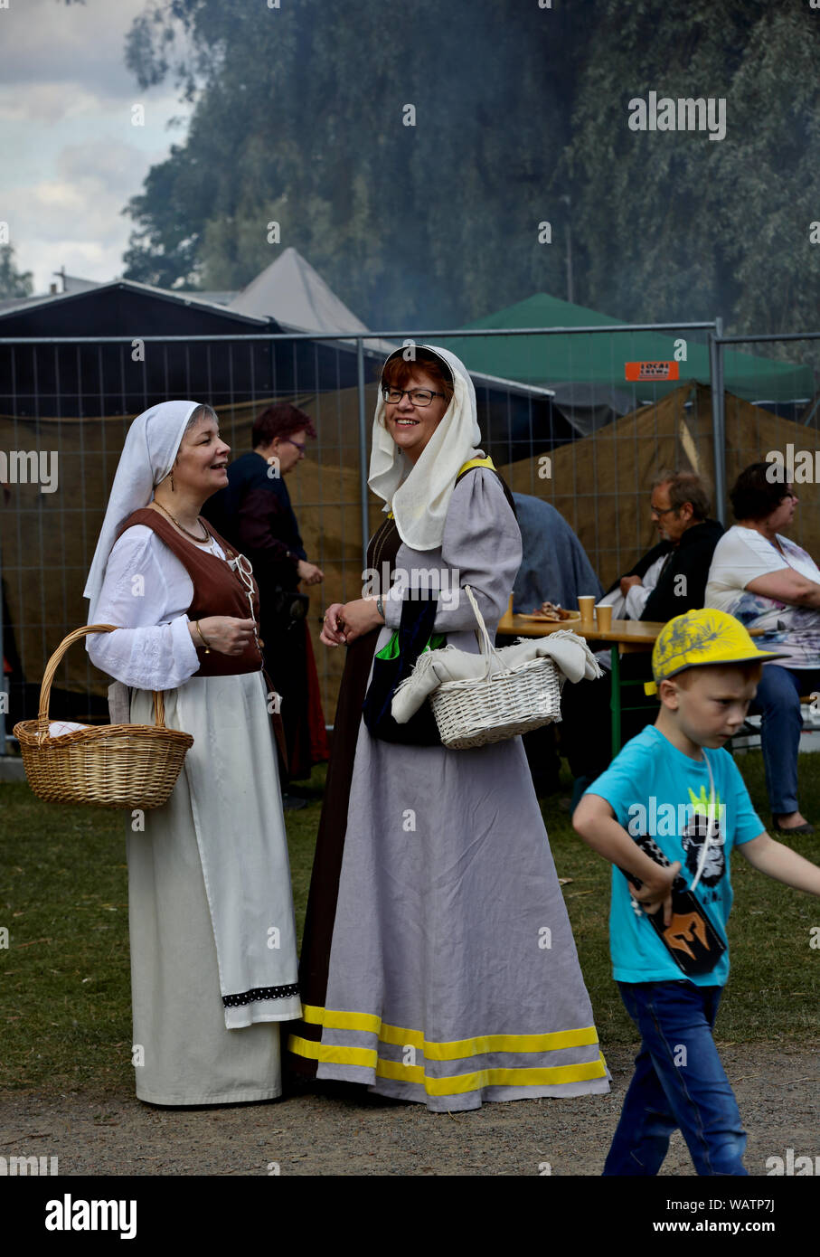 Hameenlinna Finland 08/17/2019 Medieval festival with craftsman, knights and entertainers. Ladies with elegant dresses having conversation in festival Stock Photo