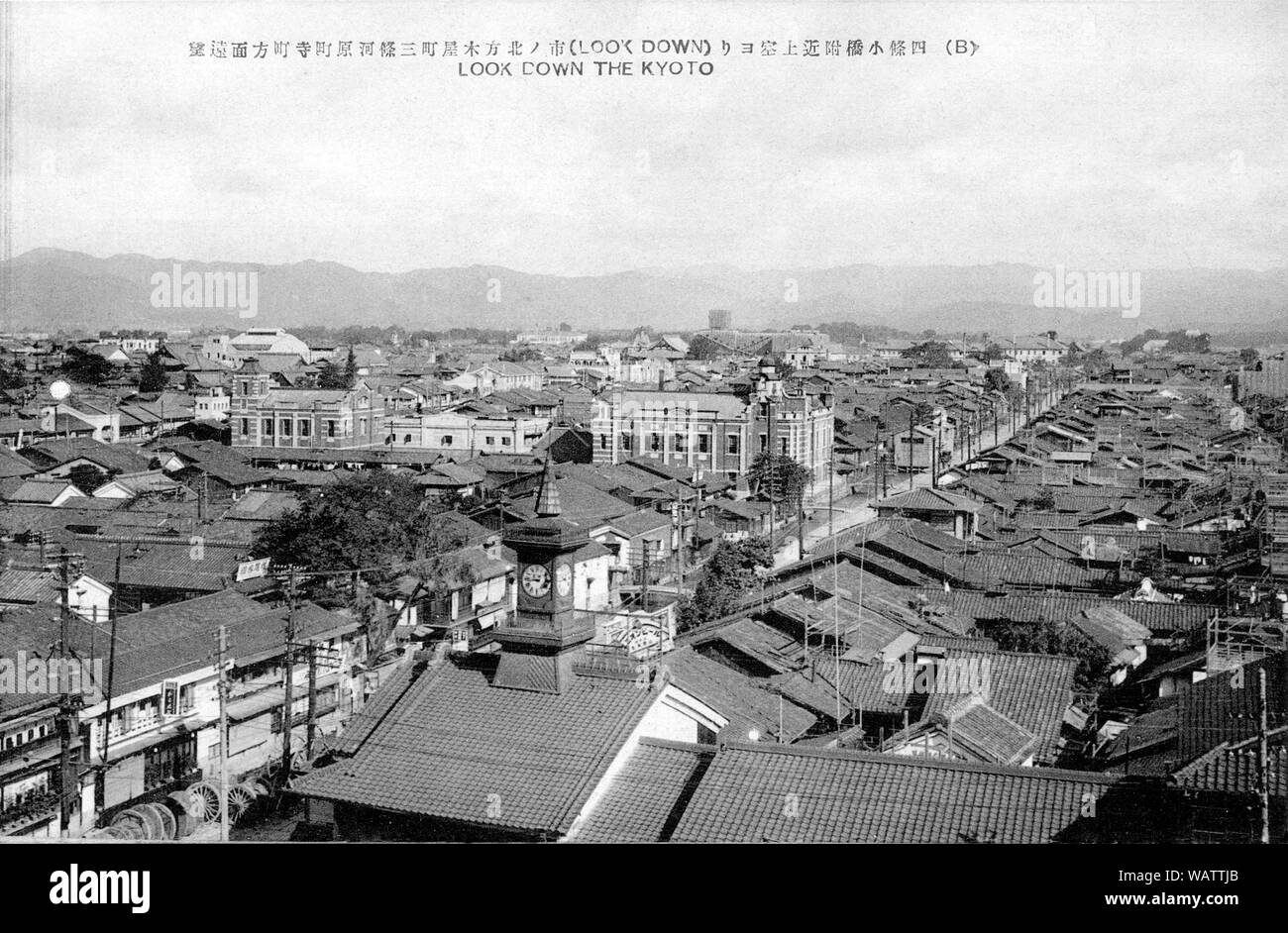 [ 1920s Japan - View on Kyoto ] —   Kiyamachi (木屋町) towards Sanjo Kawaramachi, as seen from a building nearby Shijo bridge.   The clock tower in front belonged to Murata Watch Shop (村田時計店) and was a famous landmark on Shijodori. The brick building in the very middle is the office of electric power corporation Kyoto Dento (京都電燈株式会社).   20th century vintage postcard. Stock Photo