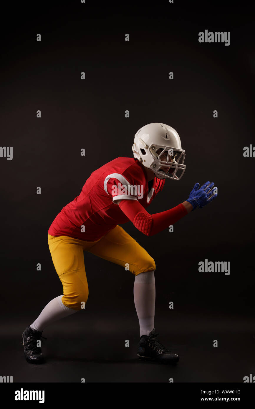 Composite image of portrait of rugby player wearing shoulder pads and  holding helmet Stock Photo - Alamy