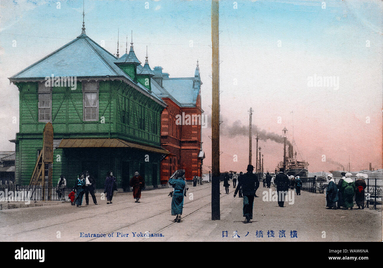 [ 1910s Japan - Yokohama Pier ] —   The pier in Yokohama Harbor, Kanagawa Prefecture.  Construction of the 19 m wide by 730 m long pier was started in 1889 (Meiji 22) and completed in 1894 (Meiji 27).   The red brick building in the back housed the Yokohama Customs Office Inspection Bureau (税関監視課庁舎) and was completed in the same year as the pier.  20th century vintage postcard. Stock Photo
