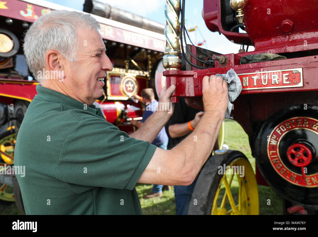 Alan Rundle from Lincolnshire, polishes the name plaque of his families Foster Showmans Tractor 'Venture', at the Great Dorset Steam Fair, where hundreds of period steam traction engines and heavy mechanical equipment from all eras gather to showcase Great Britain's rich industrial, agricultural and leisure history, at the annual show taking place over the August Bank Holiday weekend from Thursday 22nd to Monday 26th August. Stock Photo