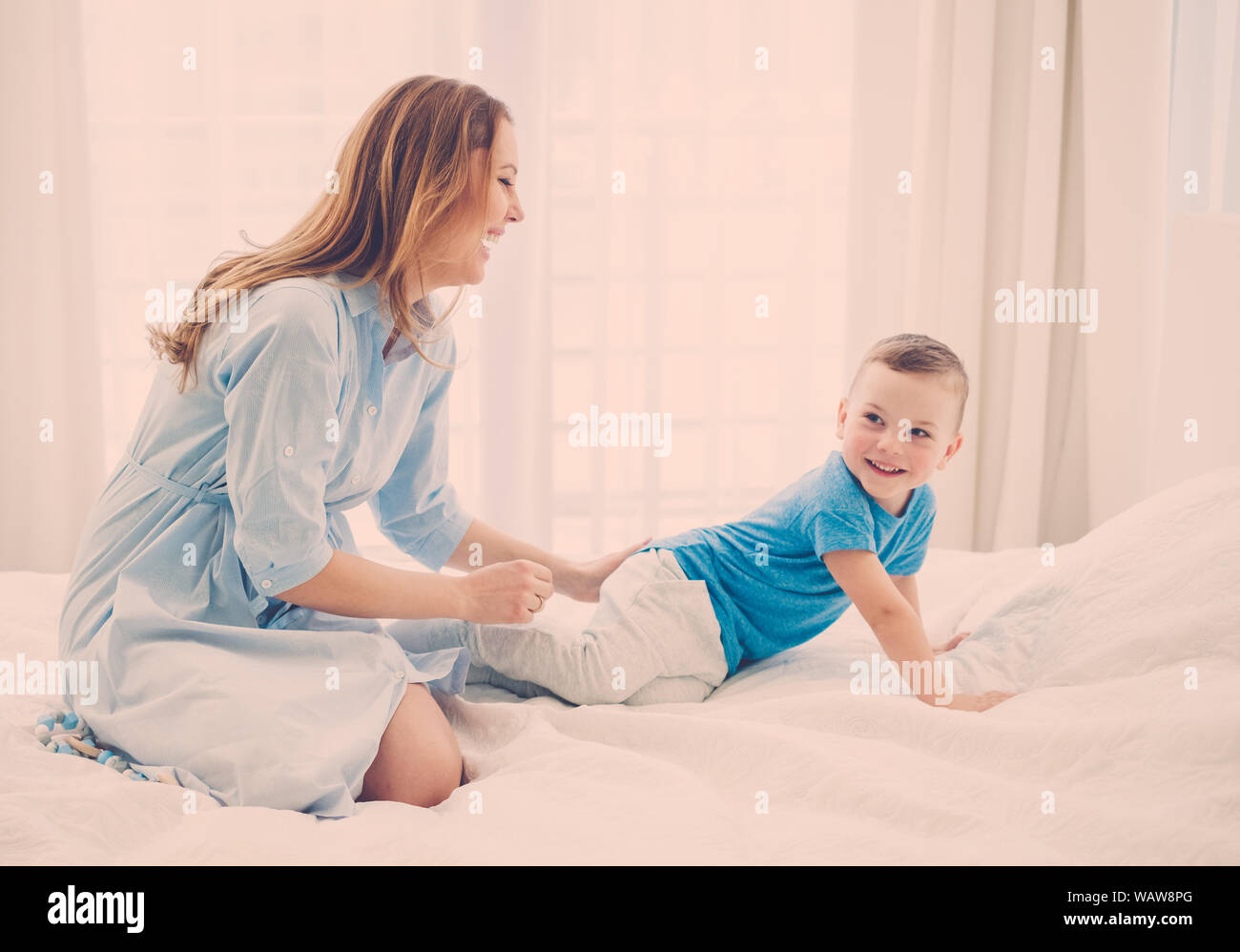 Beautiful middle aged mother with her child in a bed Stock Photo Alamy