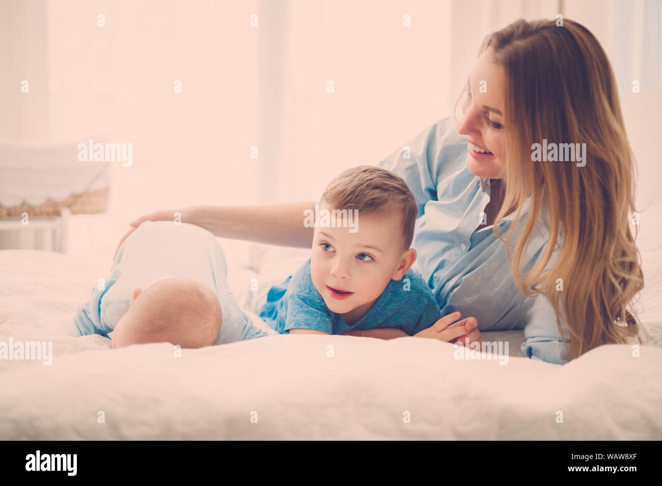 Beautiful middle aged mother with her child in a bed Stock Photo Alamy