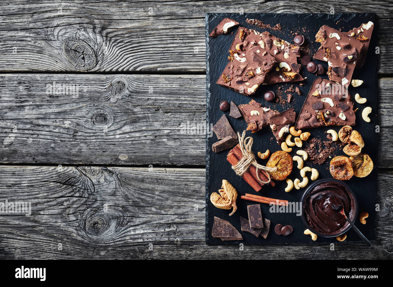 homemade chocolate bar with dried figs and cashew filling on a black