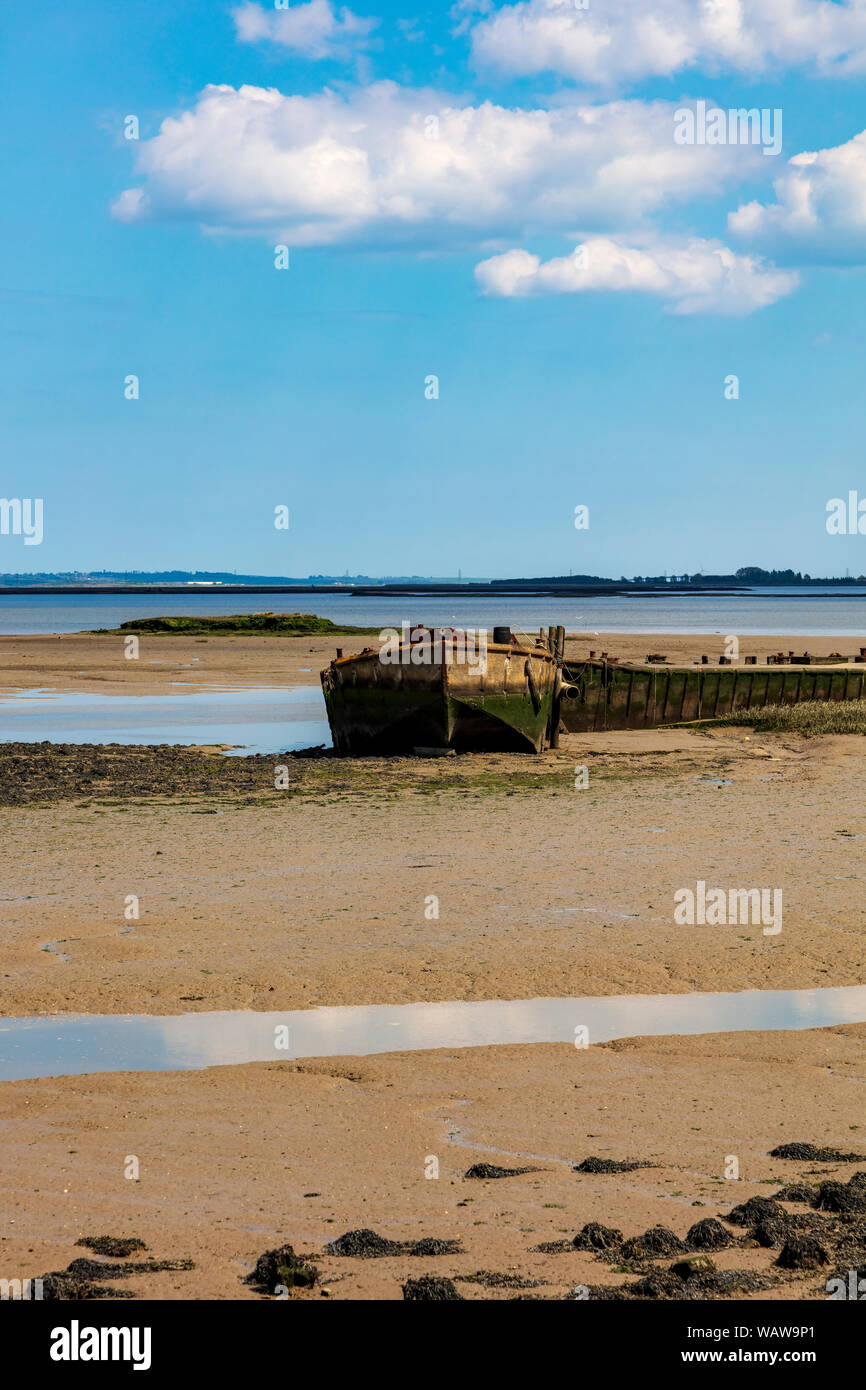 Sunken barges give protection to boats moored and beached at a sailing club and boat builders, on The Strand at Gillingham, Kent, UK Stock Photo