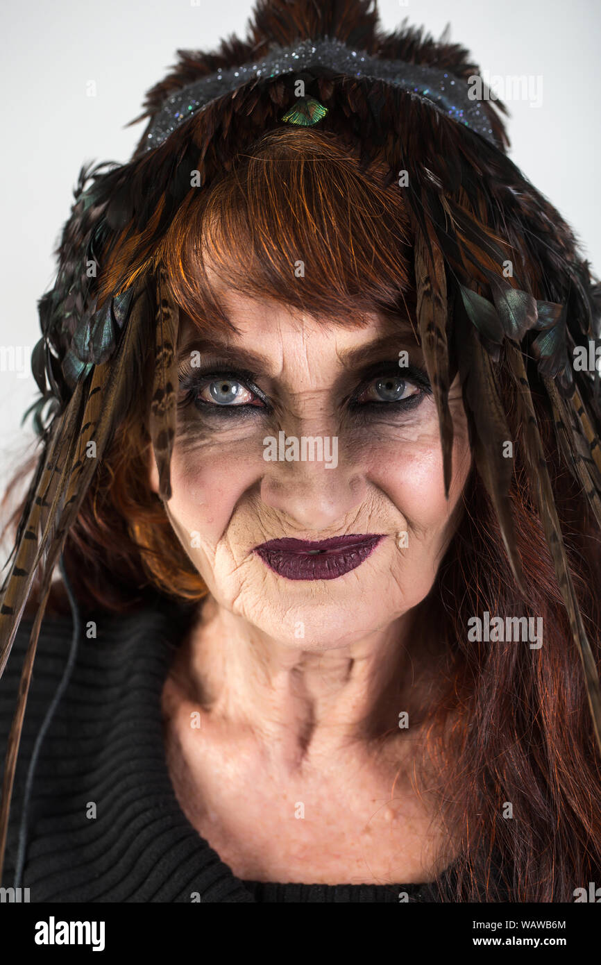 Halloween old lady in witch hat. woman in black with long red hair and  makeup. holiday celebration. traditional party. Halloween old woman on  white ba Stock Photo - Alamy