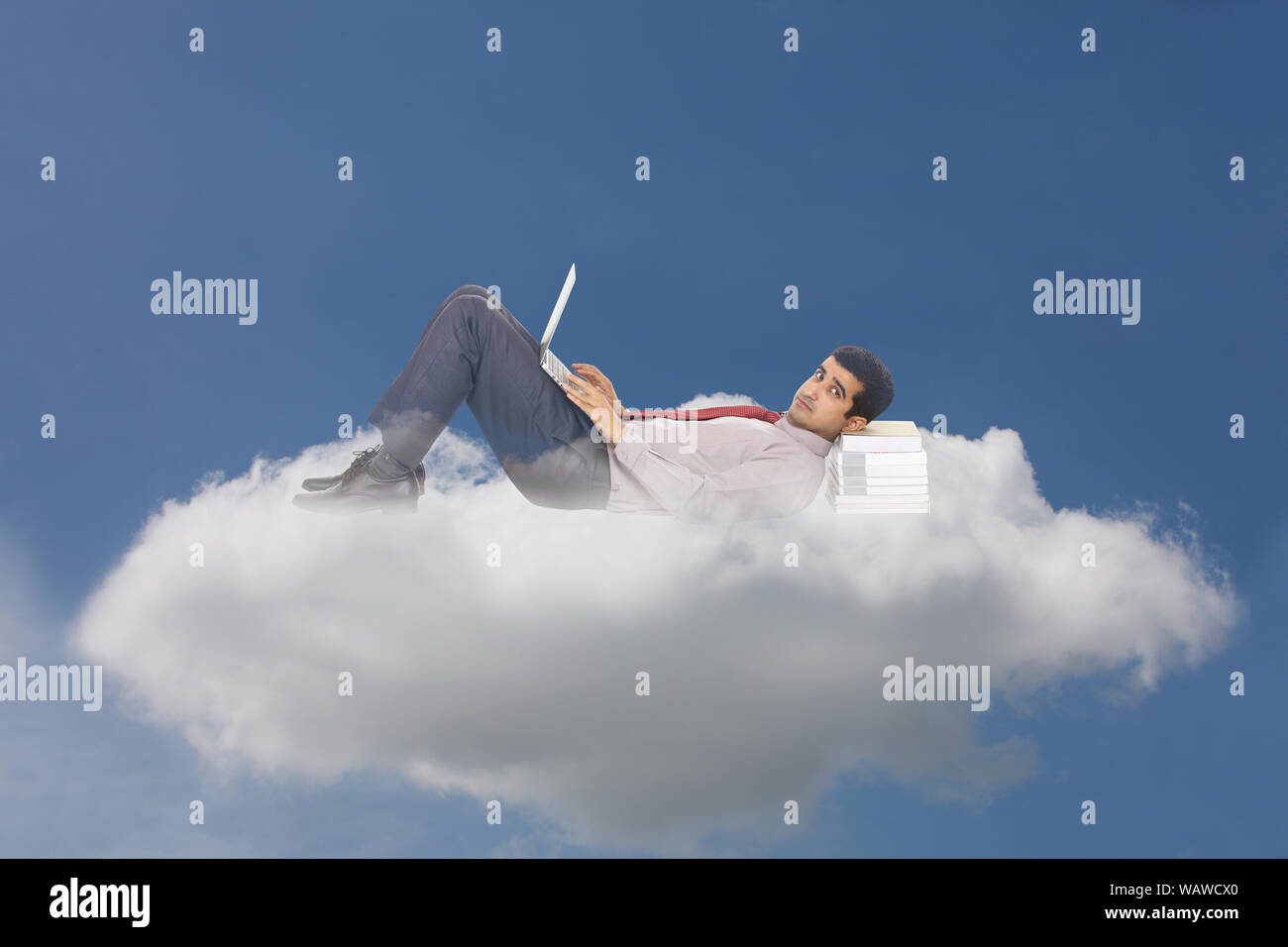 Businessman lying on clouds and using laptop concept cloud computing Stock Photo