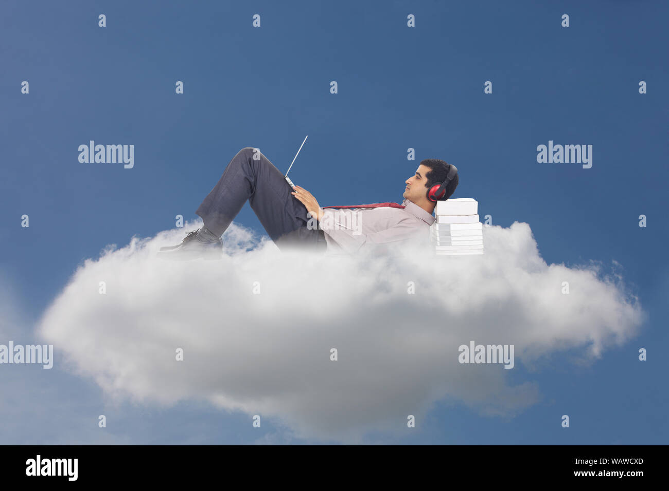 Businessman lying on clouds and using laptop concept cloud computing Stock Photo