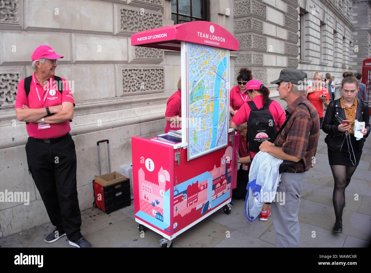 Volunteers of Team London in their pink outfit give tourist information during the summer season at Westminster, London, UK Stock Photo