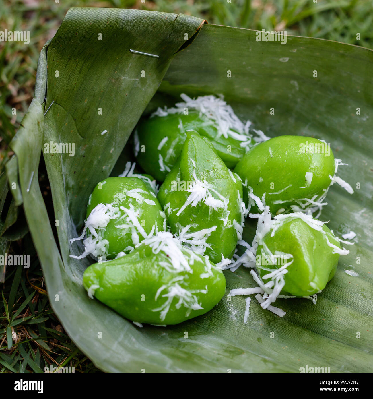 Klepon (kelepon) - sticky rice balls with caramelized coconut sugar in banana leaf, traditional Indonesian dessert, street food. Bali, Indonesia Stock Photo