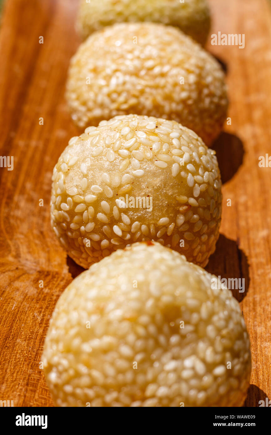 Onde-onde (ondhe-ondhe), rice flower balls coated in sesame seeds with green bean powder or black sticky rice inside. Traditional Indonesian dessert. Stock Photo