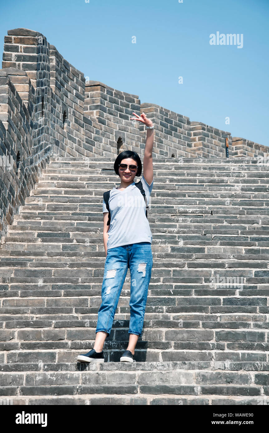 A Chinese Woman With Short Hair Wearing A Backpack Showing A