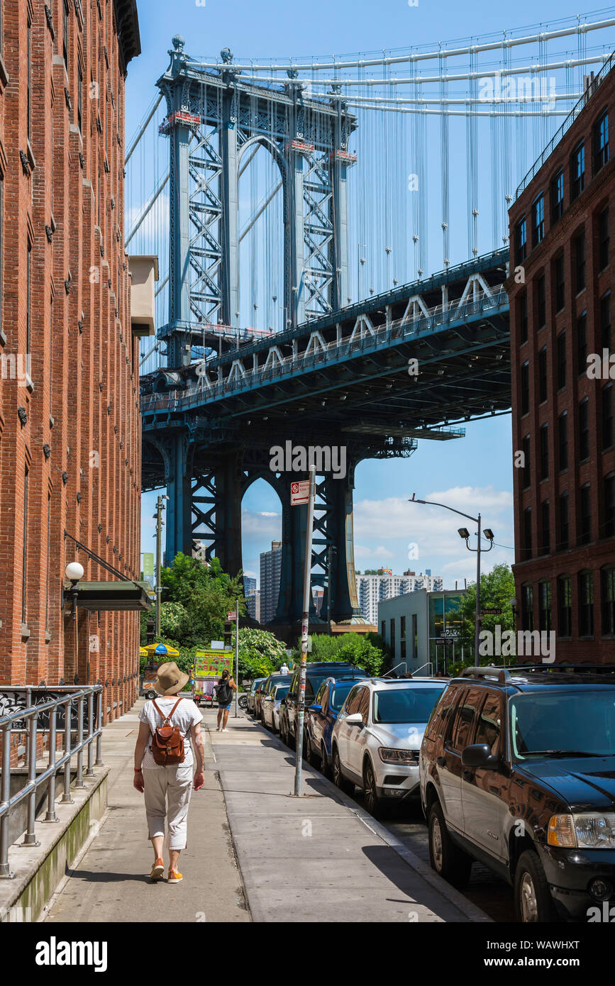 Dumbo Brooklyn, rear view of a mature woman approaching the Manhattan Bridge in Washington Street in the Dumbo area of Brooklyn, New York City, USA. Stock Photo